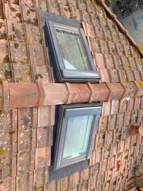 Deux fenêtres de toit Velux posées sur une couverture en tuiles