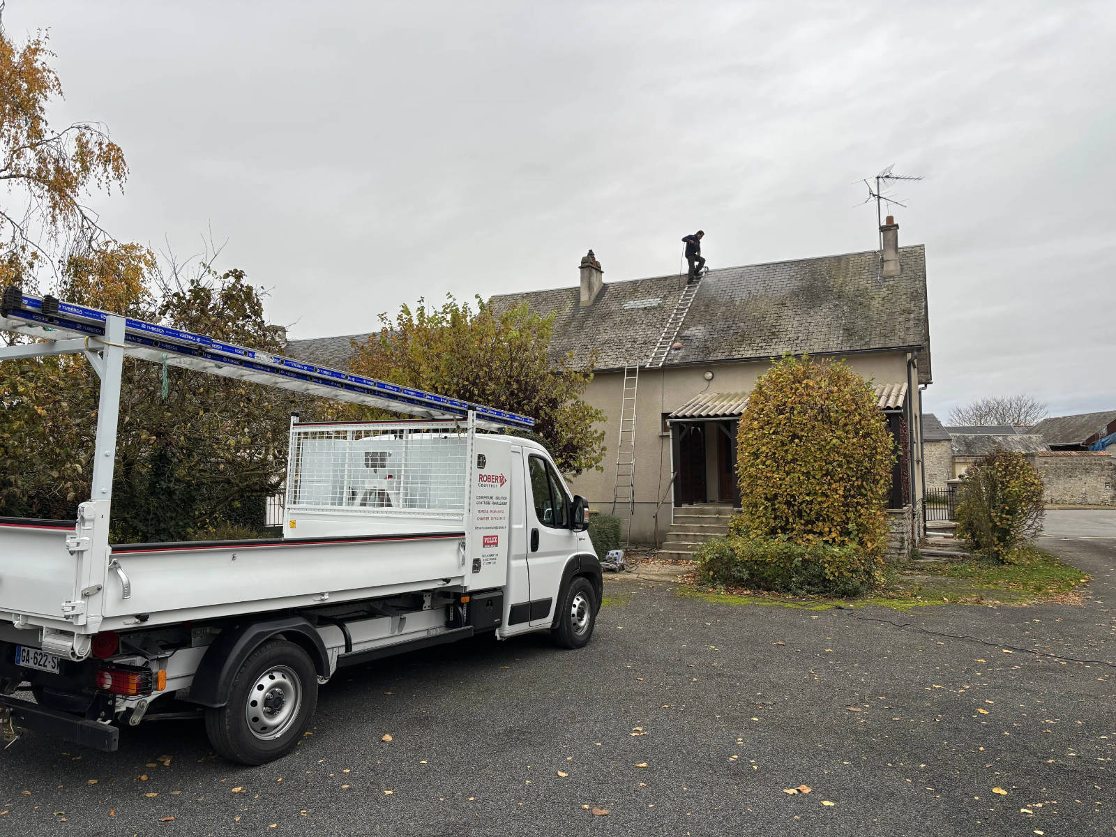 Camion Robert B. Couvreur garé devant une maison dans les Yvelines pendant un chantier de nettoyage de toiture