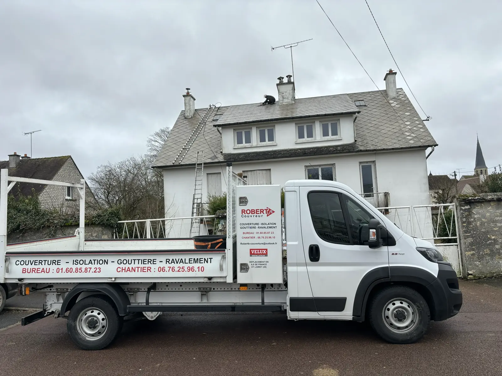 Camion Robert B. Couvreur devant une maison, réparation de toiture en cours sur le toit — prestation proposée à Houilles